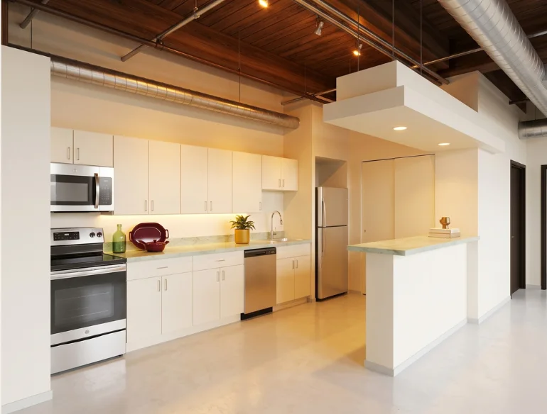 Open loft kitchen with white cabinetry, stainless appliances and a breakfast bar under exposed ductwork